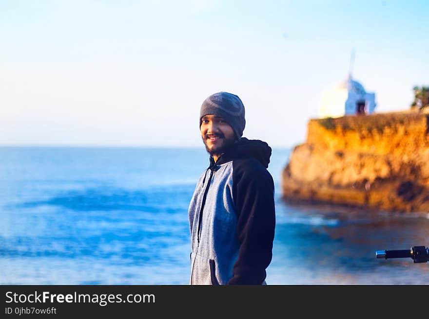 Man Wearing Gray Knit Cap and Pullover Hoodie Beside Beach