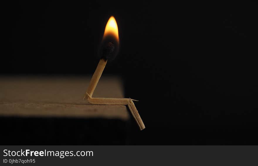 Lighted Matchstick on Brown Wooden Surface