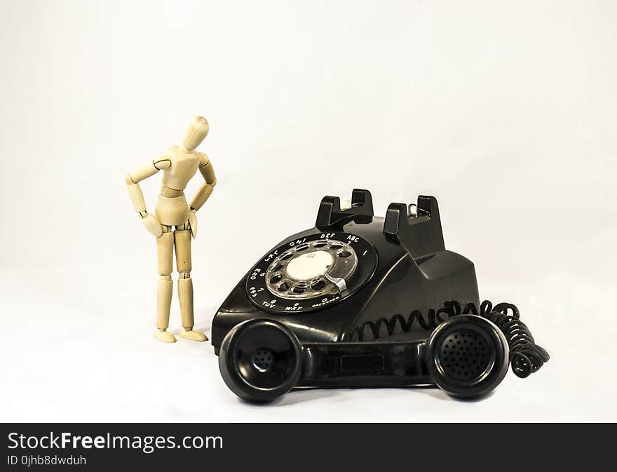 Black Rotary Telephone Beside Beige Manekin