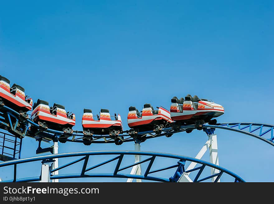 Red and White Roller Coaster on Railings