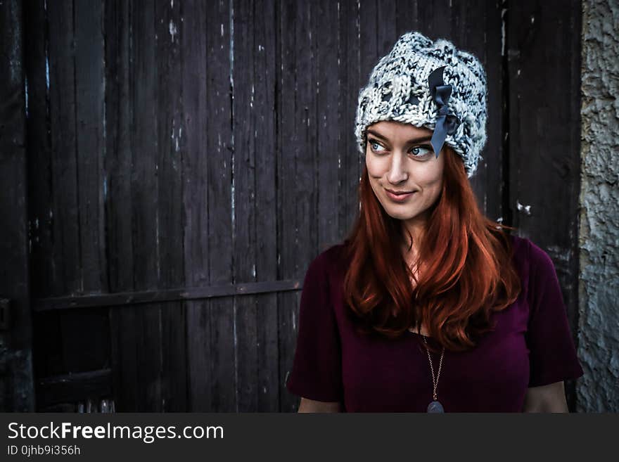 Woman Wearing Maroon Short-sleeved Shirt and White and Grey Knit Cap