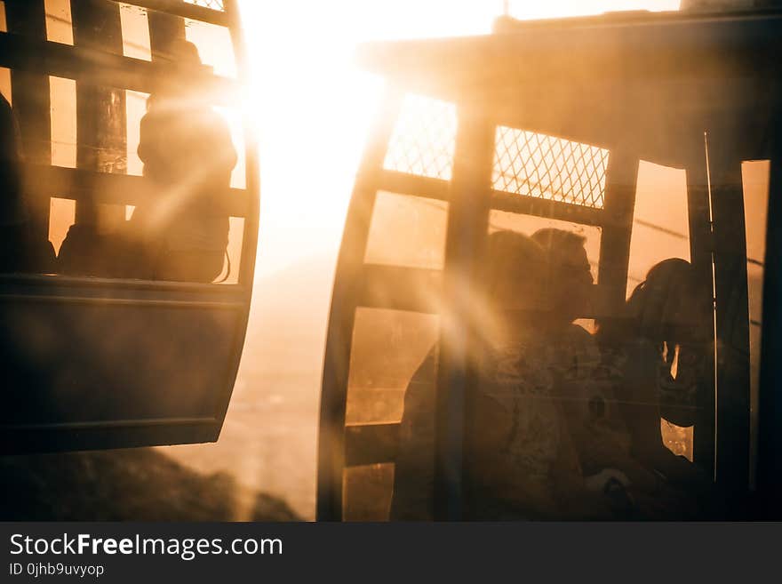 People Riding Cable Carts during Sunset