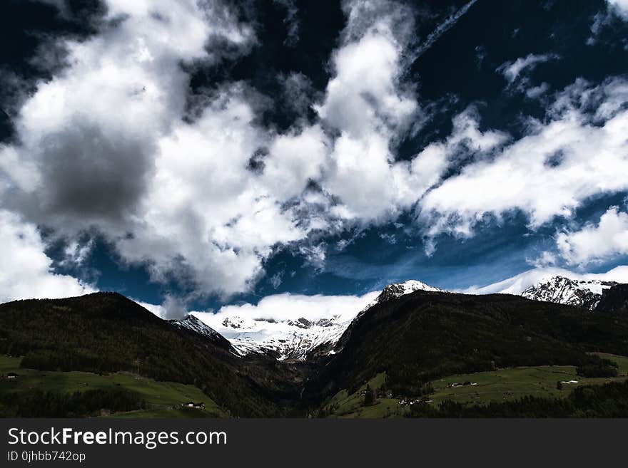 Photo Green Land Near Mountains Under Sky