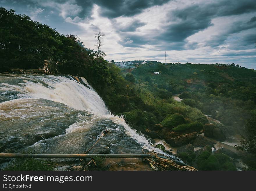 Waterfalls Beside Green High Trees Under White Sky at Daytime