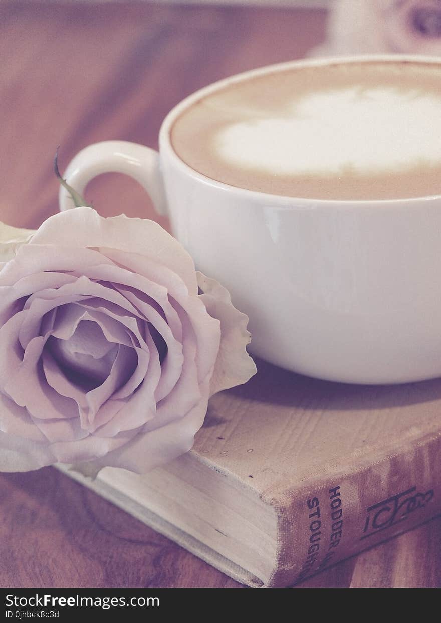 Photography of Flower Beside Coffee on Top of Book