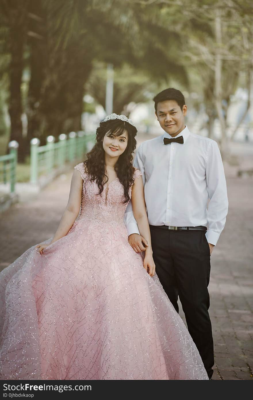 Woman Wearing Pink Wedding Gown Standing Next to Man Wearing White Dress Shirt