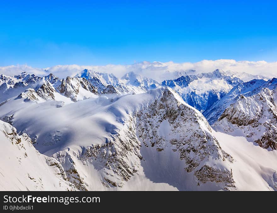 Areal Photography Of Snow Coated Mountains Under Clear Blue Sky