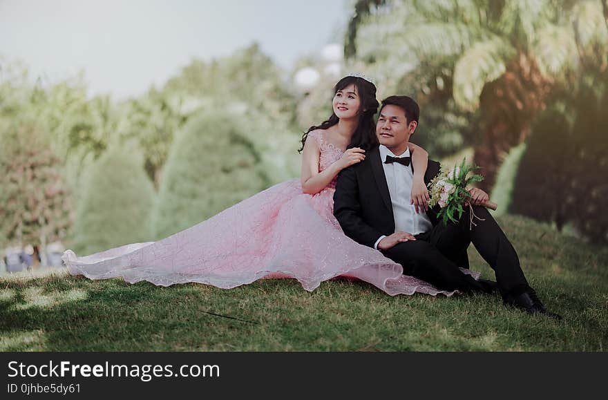 Nuptial Photo of Man in Black Formal Suit and Woman in Pink Gown