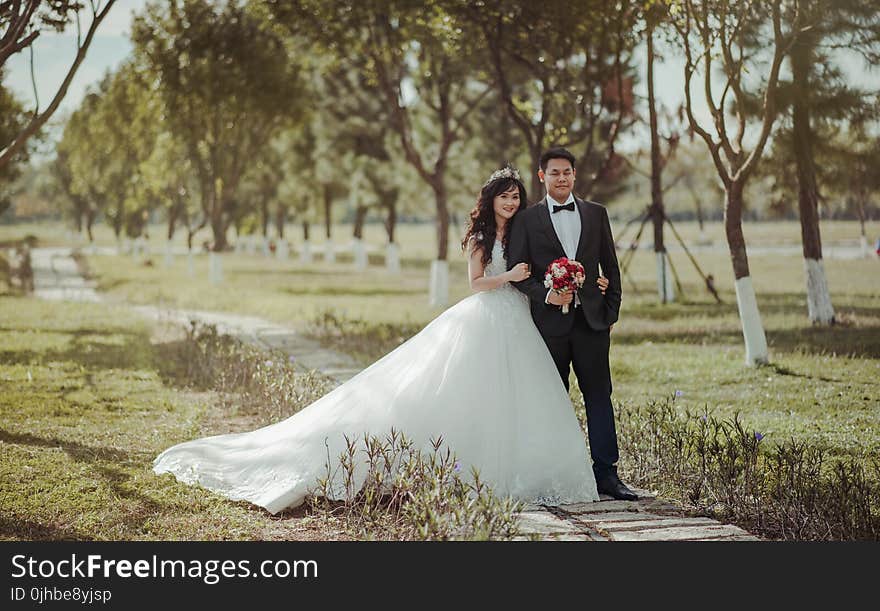 Couple Wearing Gown and Suit Jacket Standing and Pose for Picture