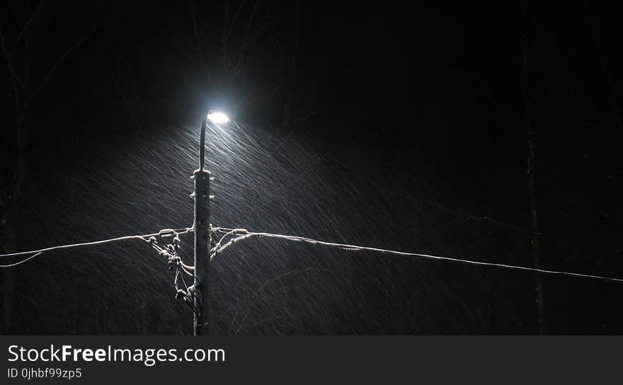 Black Electric Lamp Post With Lighted Lamp during Nighttime