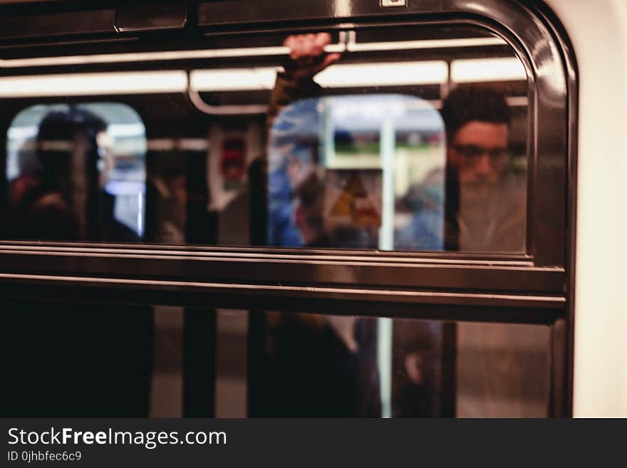 Man Standing Inside Train Waiting to Stop