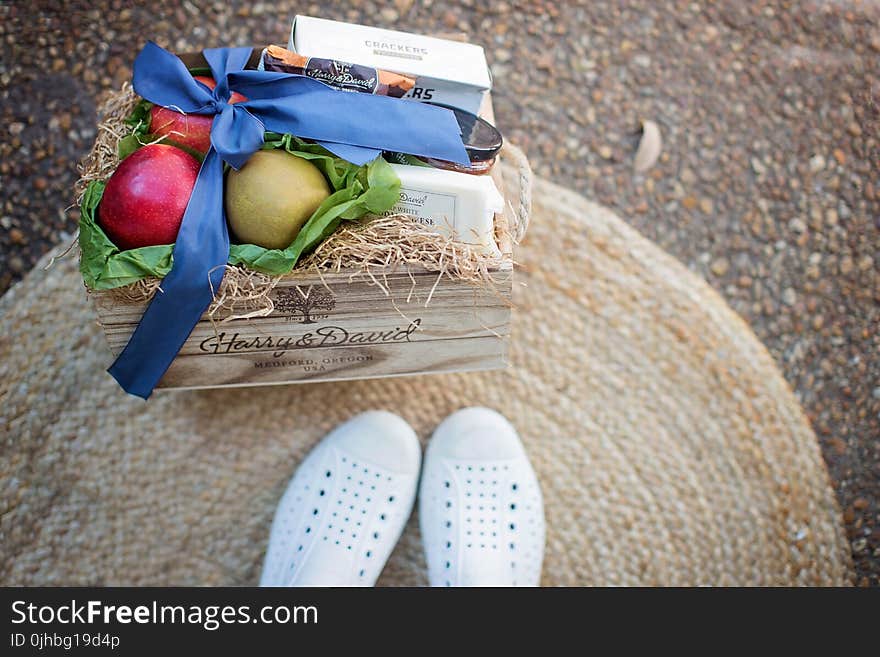 Red and Green Fruits Beside White Box on Brown Wooden Box