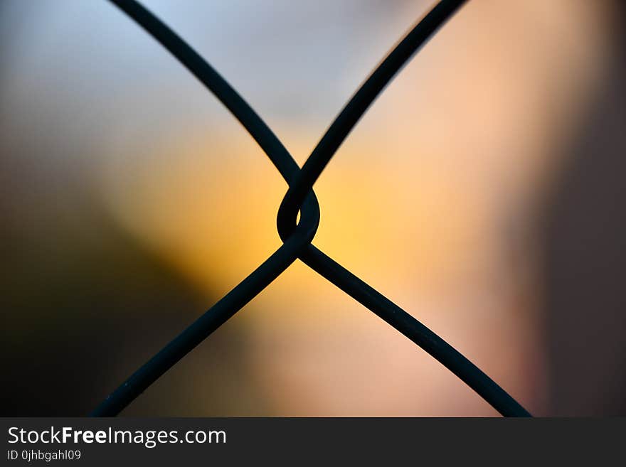 Shallow Focus Photography of Silhouette of Cyclone Wire