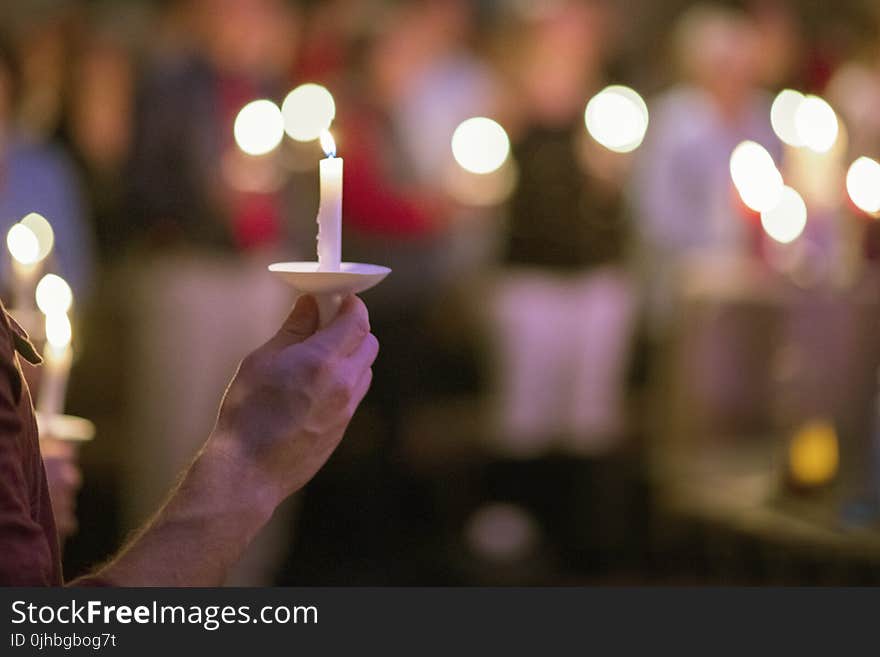 Person Holding White Taper Candle