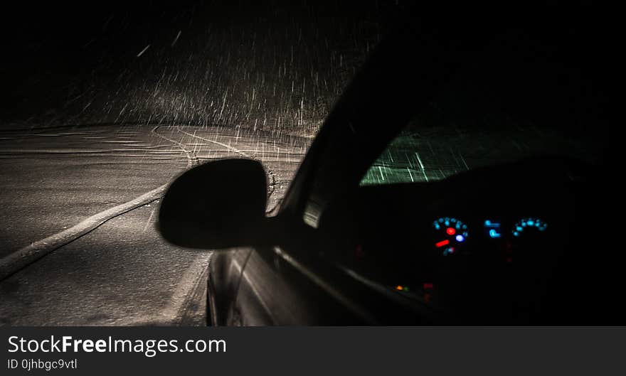 Black Car on Roadway While Raining during Nighttime