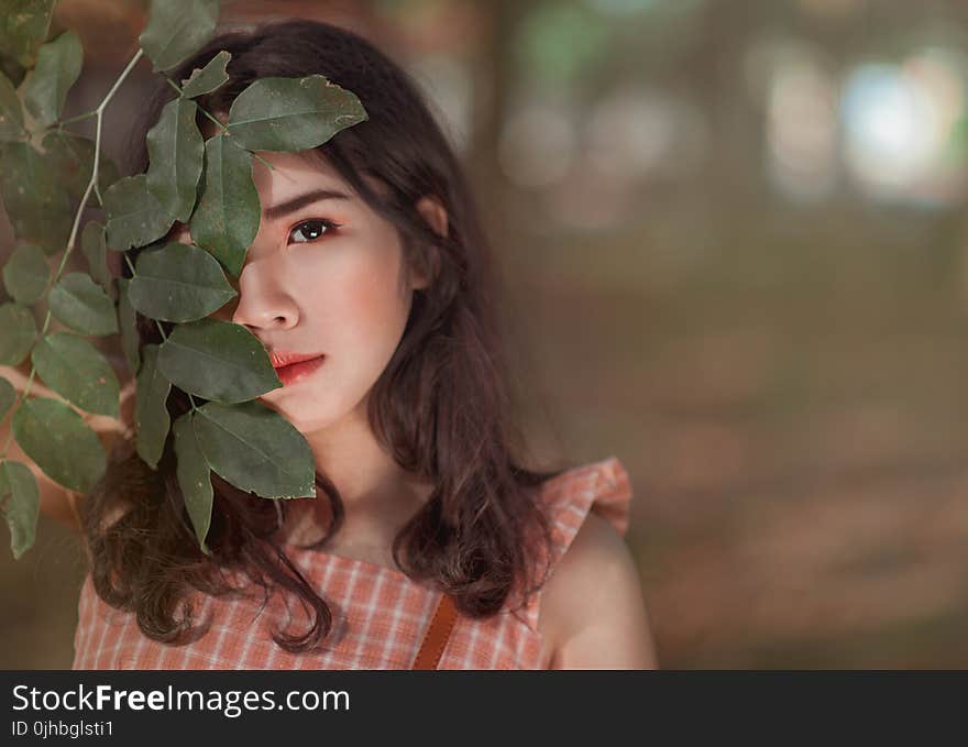 Woman Wearing Pink Sleeveless Top Behind Leaves