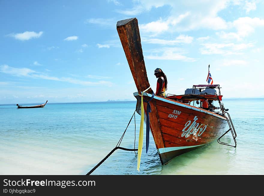 Brown Boat Docked at the Seaside Under the Clear Blue Skies