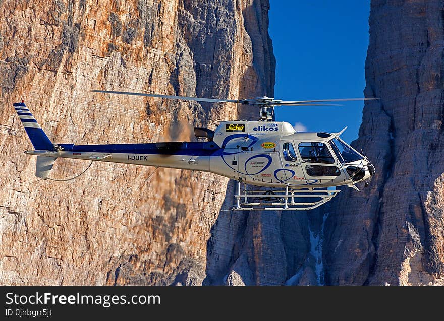 Selective Photograph of White Helicopter Near Brown Mountains