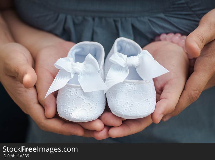 Person Carrying Pair of Baby&#x27;s White Flats