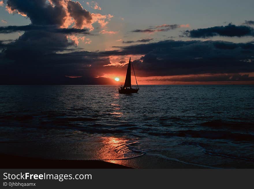 Silhouette of Sailboat on Body of Water during Sunset