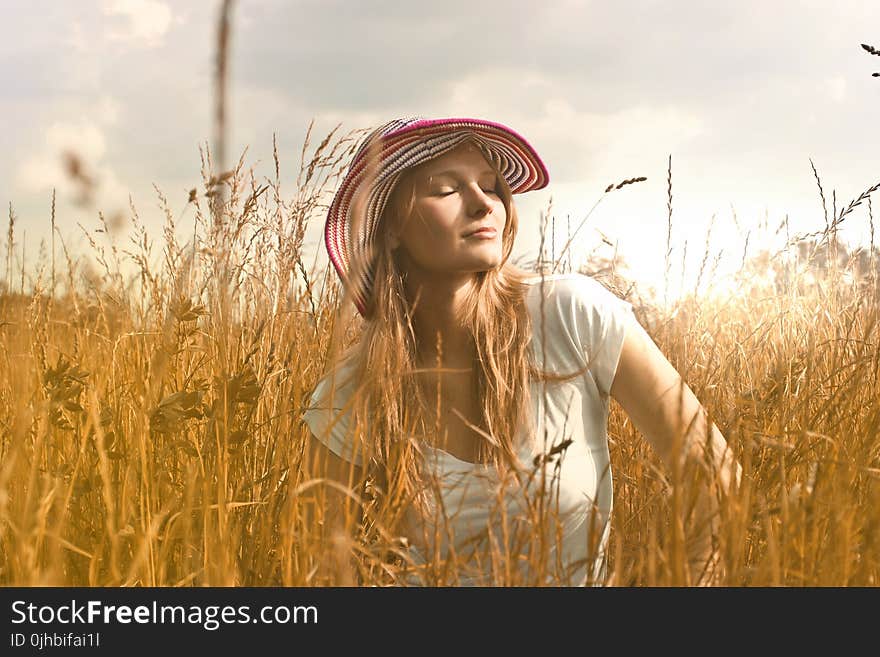 Woman Wearing White Top and Red and White Sunny Hat