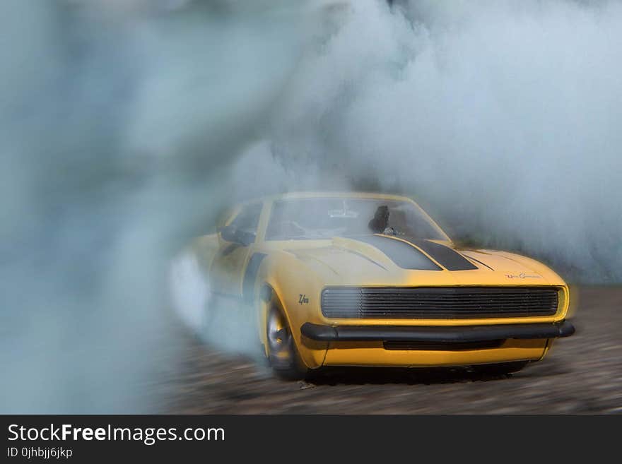 Classic Yellow And Black Sports Car Drifting On Road With Smoke