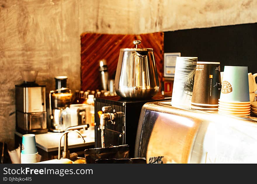 Stainless Steel Coffee Pot and Disposable Cups on Top of Counter