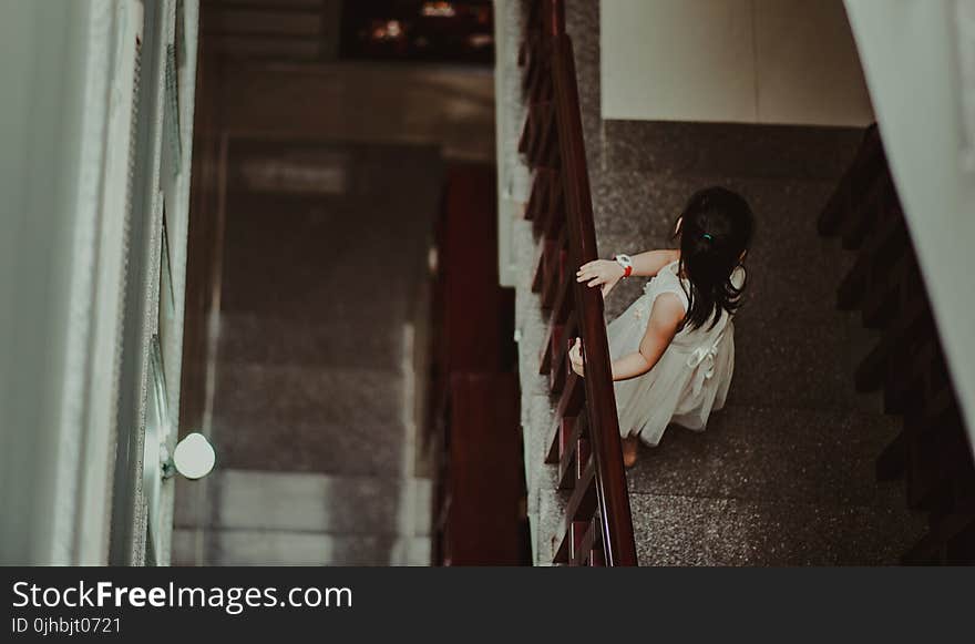 Girl in White Dress Standing in Front of Railings