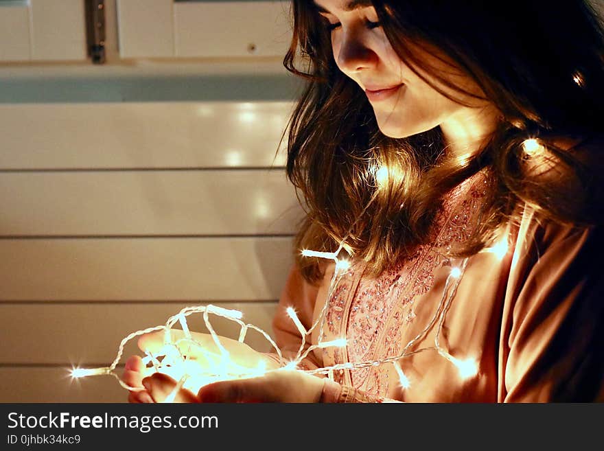 Woman Holding Lighted String Light