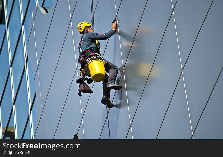 Man Cleaning the Glass of Building