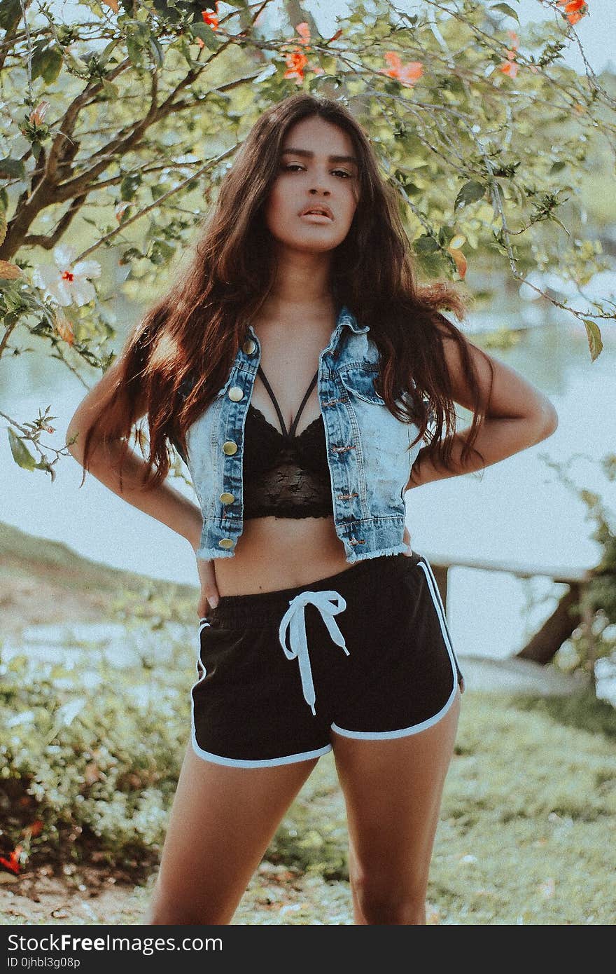 Woman in Gray-washed Denim Sleeveless Collared Cropped Top Standing With Background of Calm Body of Water