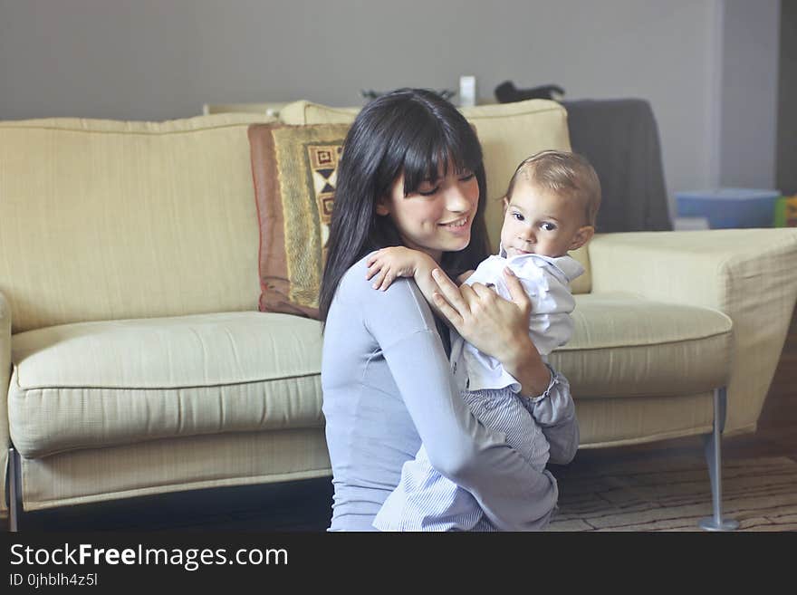 Woman in Gray Sweater Carrying Toddler in White Button-up Shirt