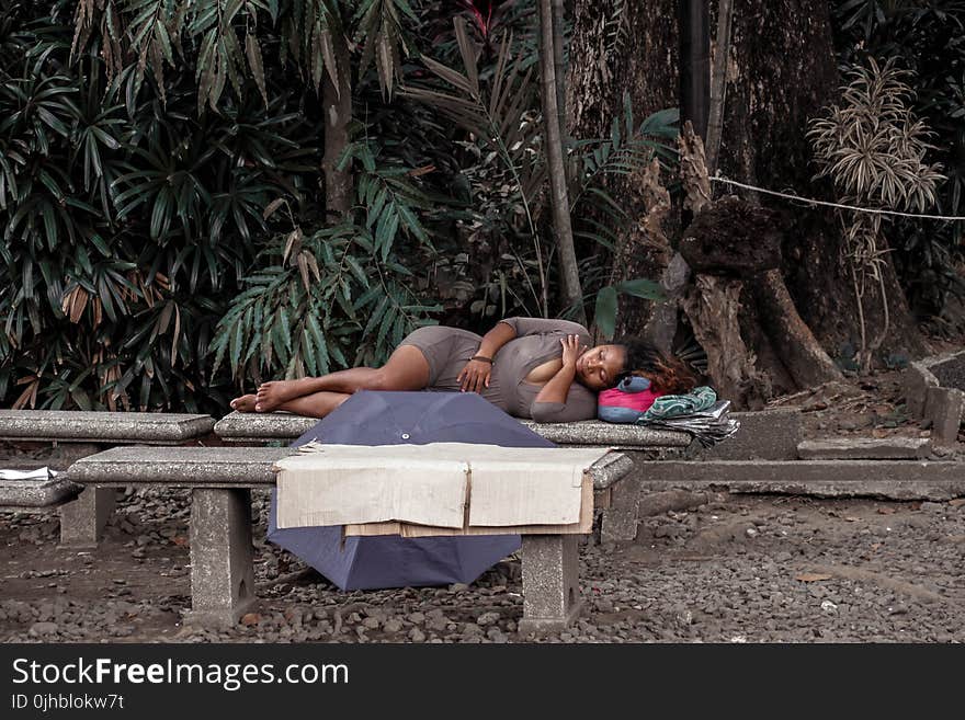 Woman in Gray Dress Lying on Bench