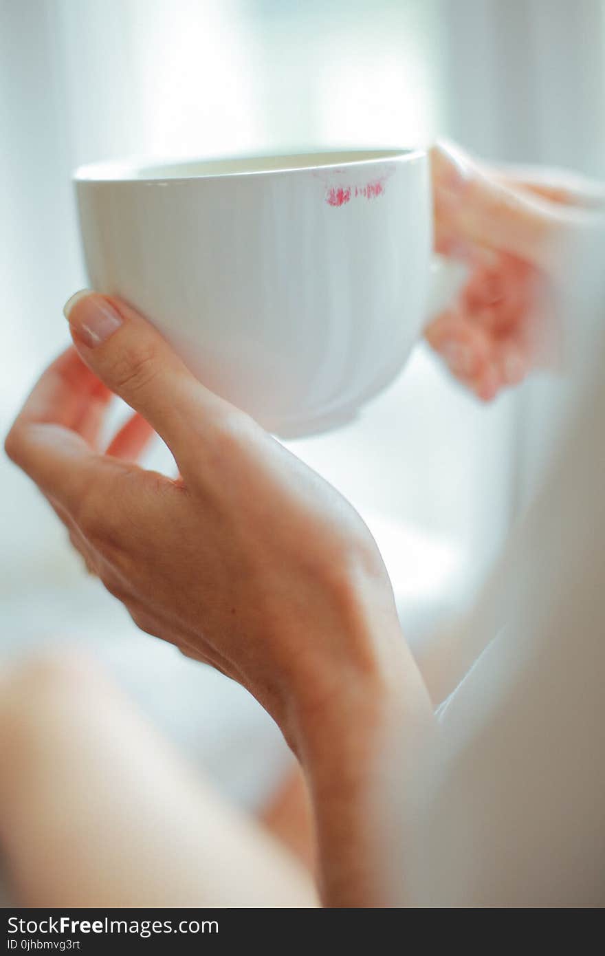 Person Holding White Ceramic Teacup