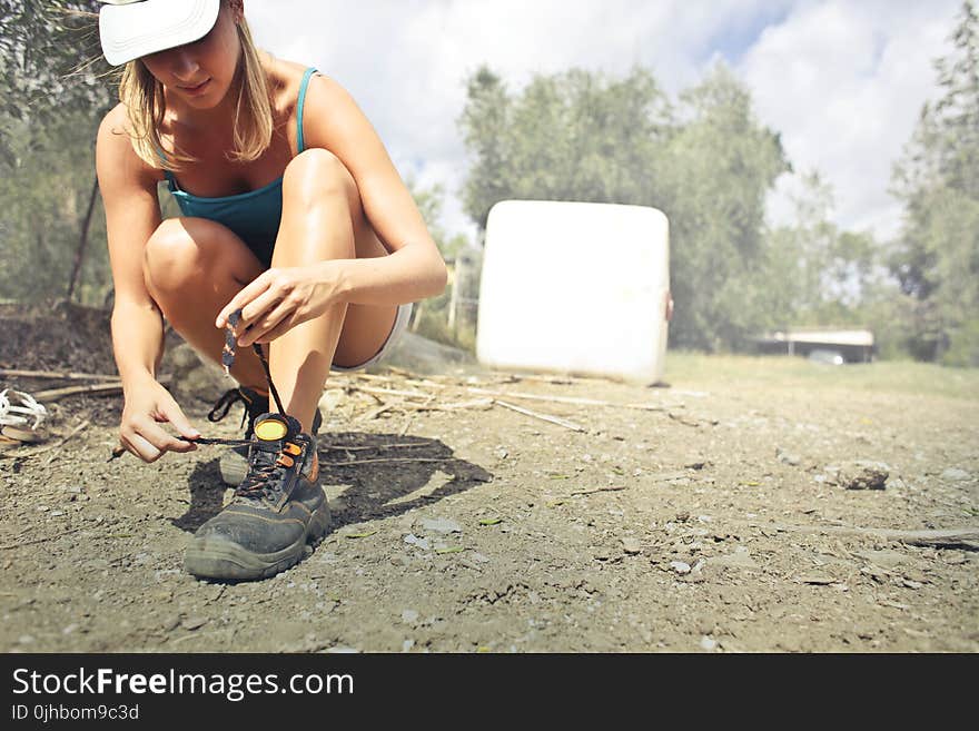 Photography of a Woman Tying Her Shoe