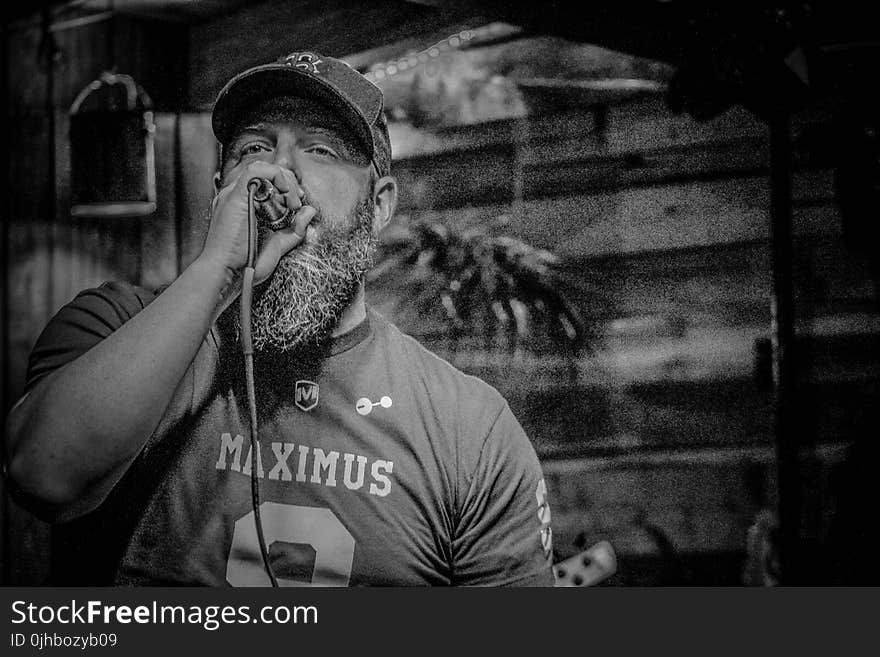 Monochrome Photography of Man Holding Microphone