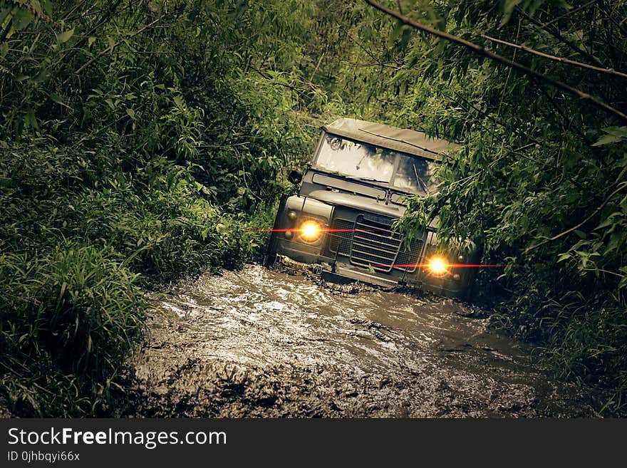 Green Car Running of Flooded Road