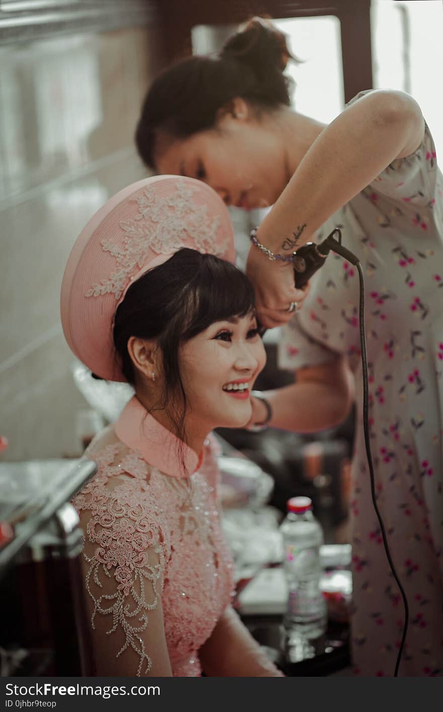 Woman in Pink Collared Blouse Smiling While Sitting