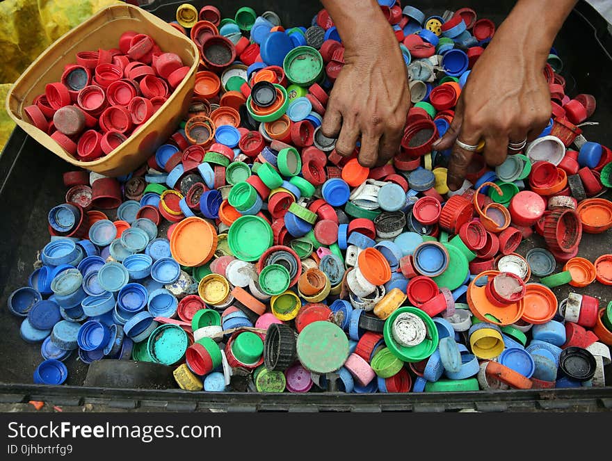 Person Hands on Assorted-color Plastic Lid Lot