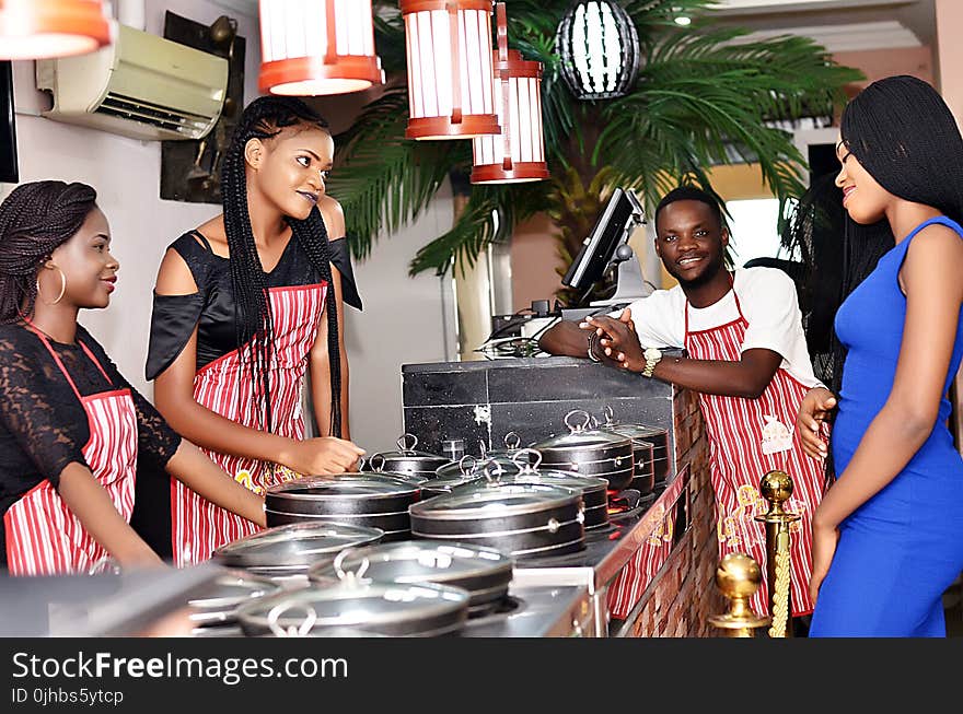 Three Woman and Man Wearing Apron