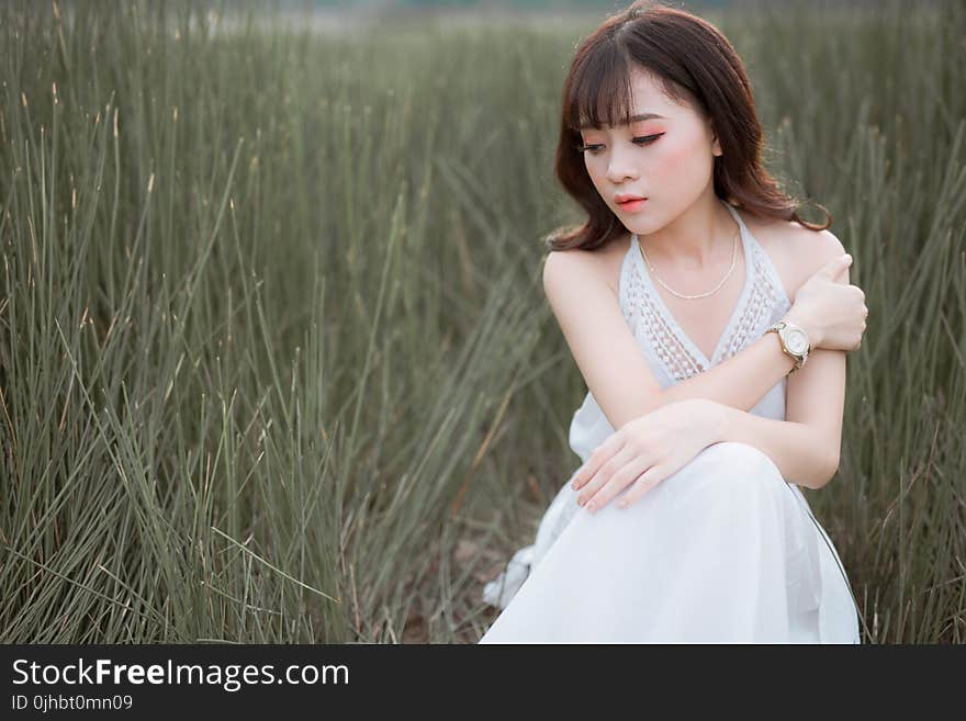 Woman Wearing White Halter Dress Surrounded By Grass