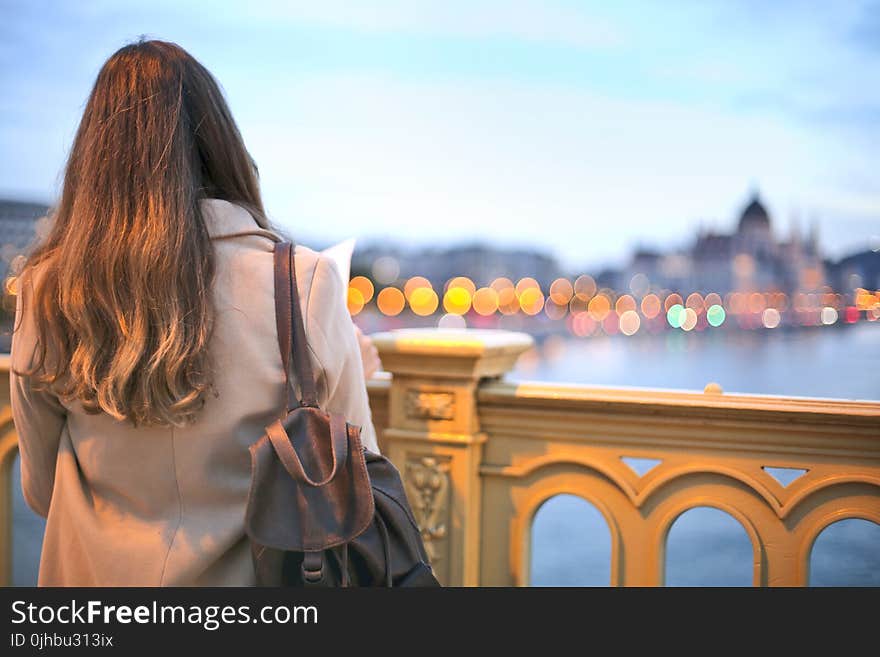 Woman Wearing Trench Coat And Black Leather Backpack