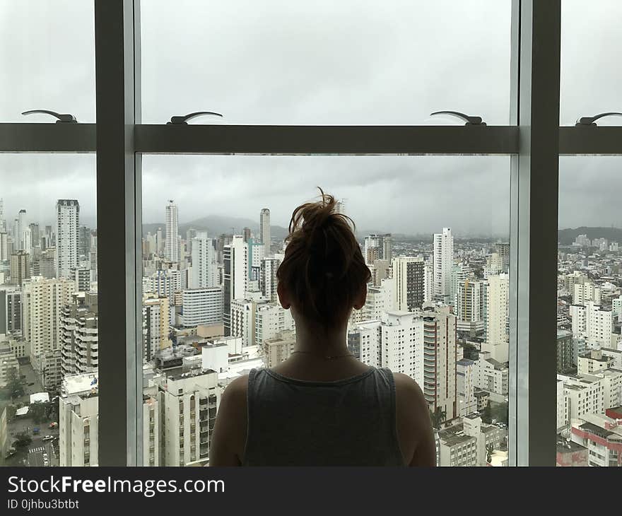 Woman Standing Near Glass Window