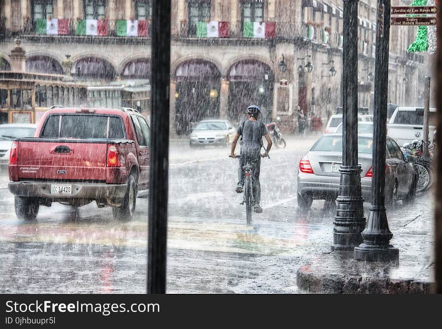 Person Riding a Bicycle during Rainy Day