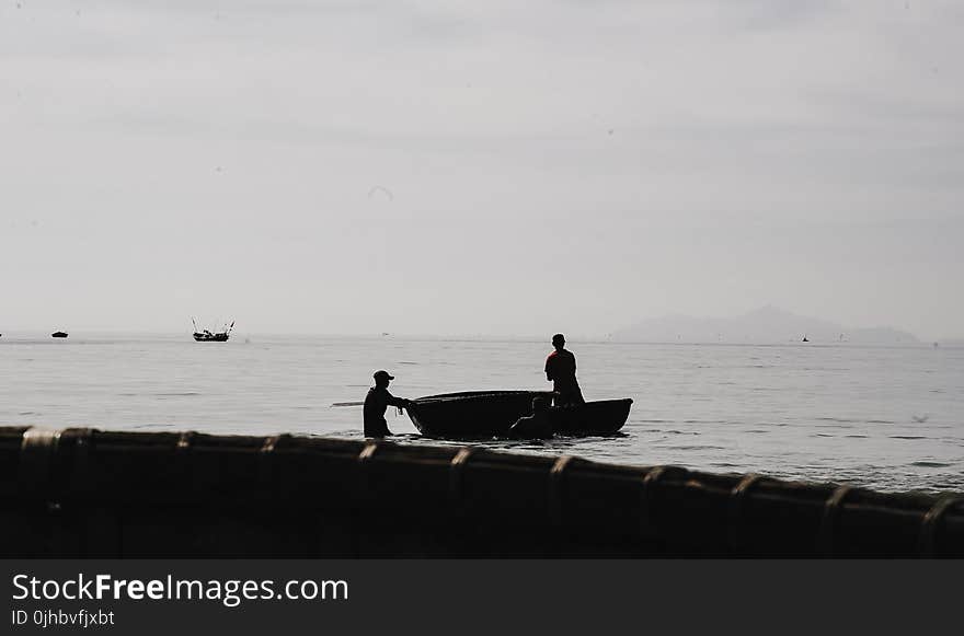 Two Person Riding Boat on Body of Water