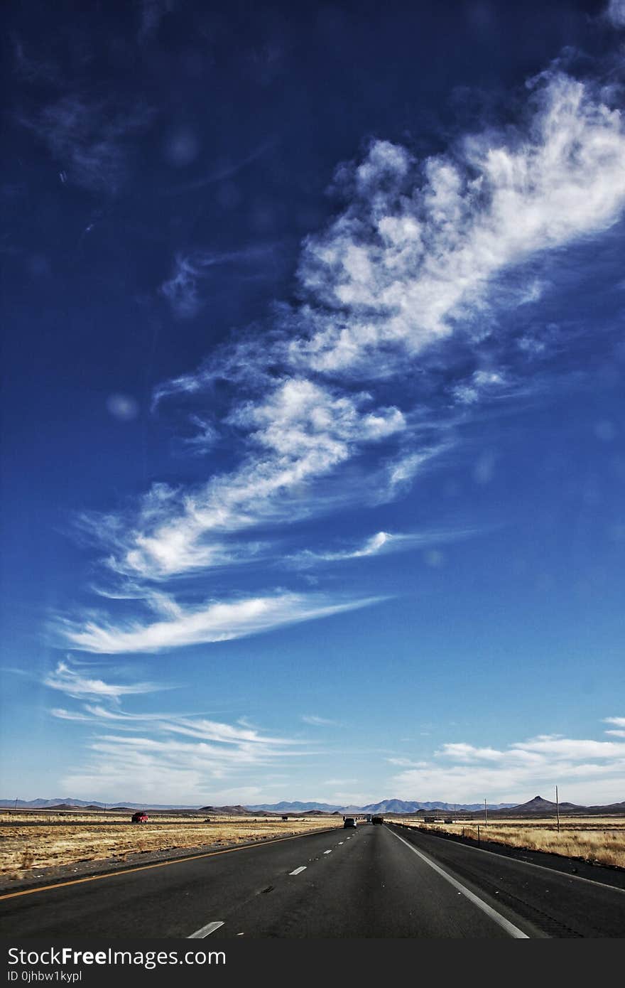 Cirrus Clouds over Empty Black Road