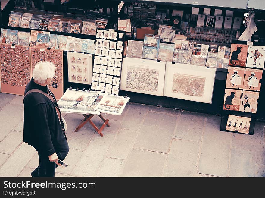 Photo of an Old Man Looking at the Pictures