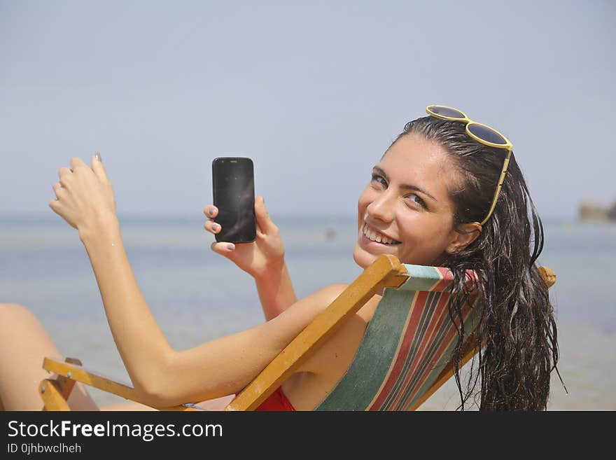 Woman Sitting On Sun Lounger