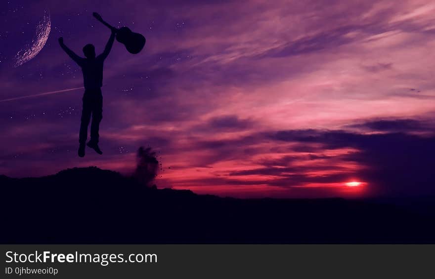 Silhouette of Man Holding a Guitar