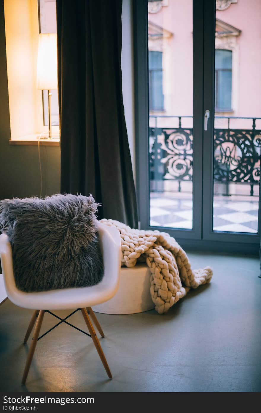 Gray Throw Pillow on White Padded Armchair